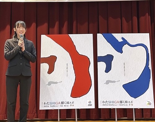 ポスター2種類並び、その横に武立さんがマイクを持って立っている様子の写真。