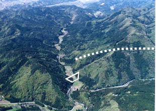 芹谷ダム計画地の上空からの写真です。台形マークは支川水谷川に予定している芹谷ダムで白点線は芹川の洪水をダムに引き入れる導水トンネルです。