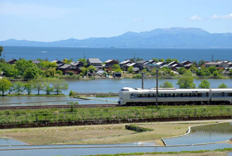 写真：琵琶湖をバックに走る電車