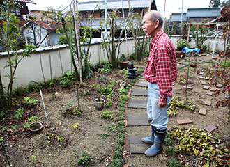 写真：庭に立つ三郎さん
