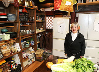 写真：台所に立つ光子さん