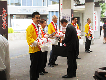 赤い羽根共同募金の街頭啓発で大津駅前に立つ様子