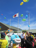 滋賀県立障害者福祉センターの「第25回記念夏祭り」でエコ風船を空に向けて飛ばしている様子。