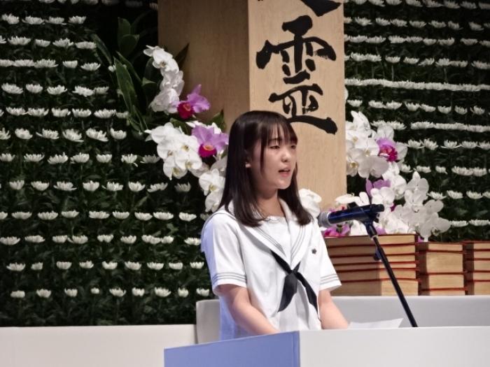 平和メッセージ作文を滋賀県立膳所高等学校柴野真秀子様が読み上げる様子