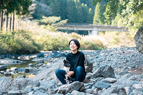 愛犬と一緒に河原で座る船崎さん