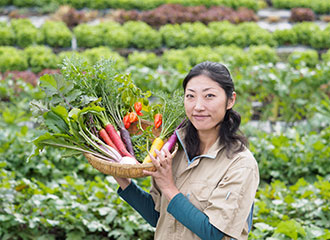 写真:農園にて野菜をとる佳奈さん