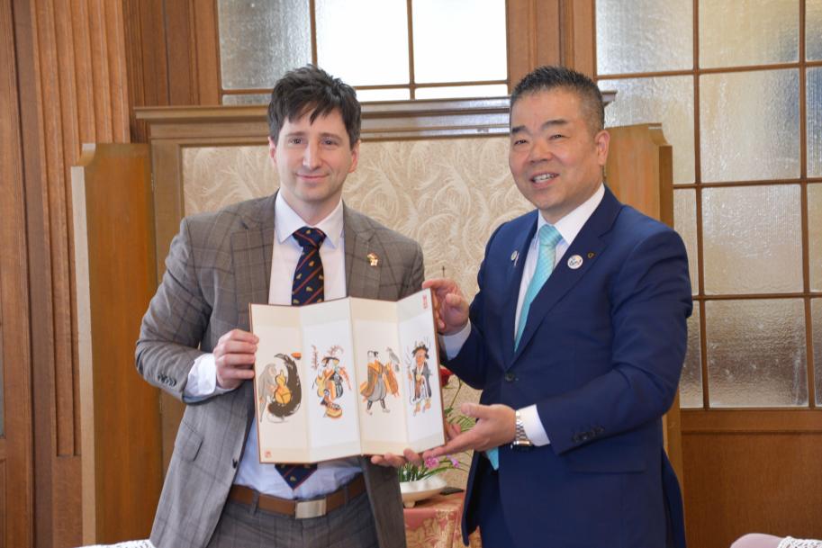 知事とケレケシュ領事館長の記念写真。領事館長の手には「大津絵」のミニ屏風が。