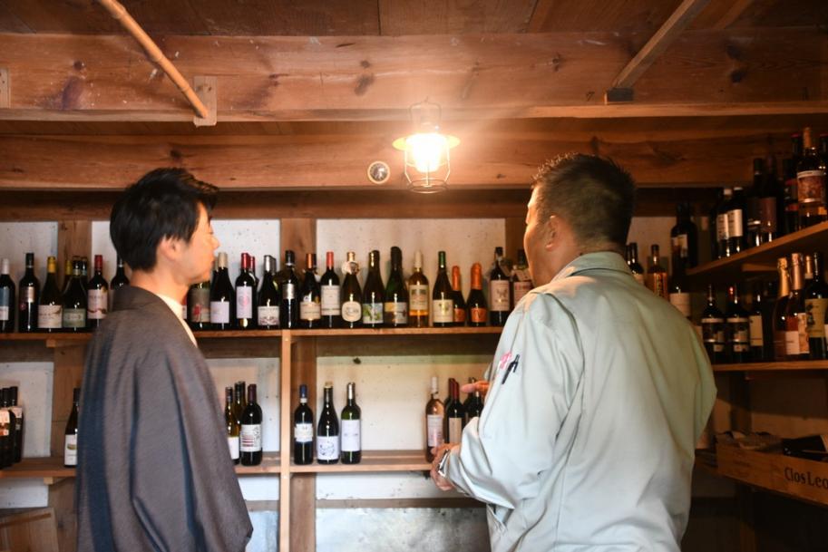 ワインセラーは蔵を活用。知事と大西代表がずらりと並んだワインを眺める。