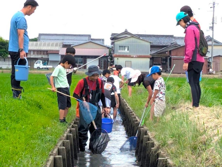 網を持って「魚道」に入る子どもたち