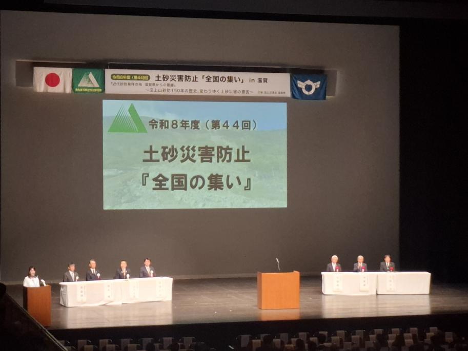 会場、ステージの様子。スクリーンには令和8年(第44回)土砂災害防止『全国の集い』と表示されている。