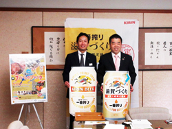 キリンビール株式会社京滋支社長と、キリンビールの看板とともに