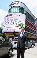 Apple Vacations &amp; Conventions 社屋ビルの電光掲示板の前