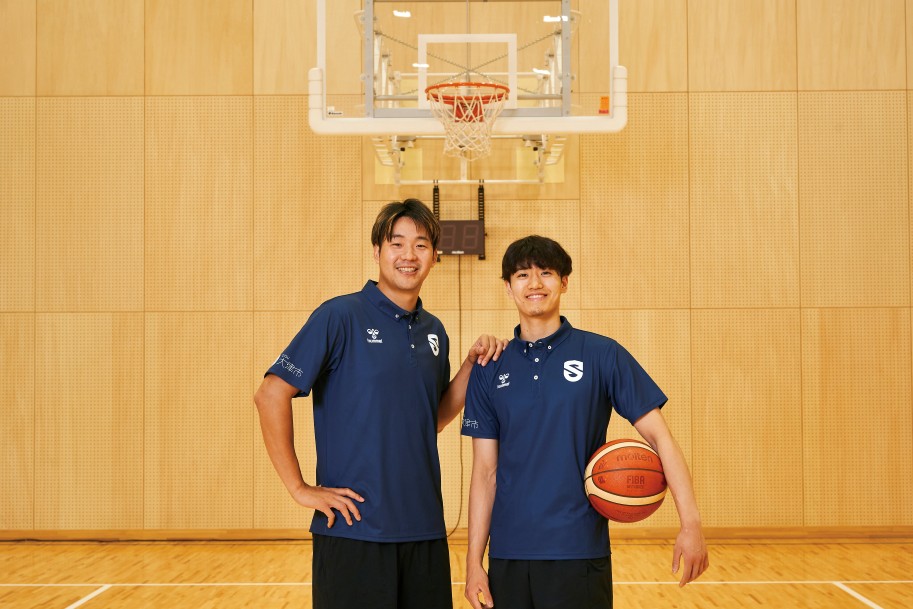 森山 修斗さん、野本 大智さんの写真。野本 大智さんの手にはバスケットボール。背景には、バスケットボールのリングが写っている。